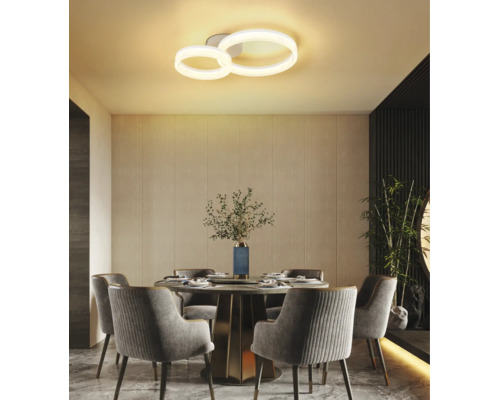 Modern LED-taklampa med två ringar i en ljus matsal med runt bord och stoppade stolar.