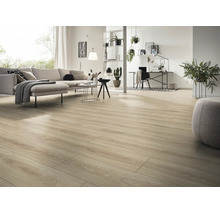 Ljust och rymligt vardagsrum med laminatgolv i trälook, modern soffa, arbetsplats och dekorativa krukväxter.