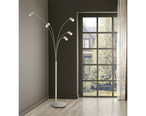 Modern golvlampa med fem justerbara armar i ett ljust vardagsrum bredvid ett stort fönster.