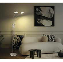 Tvålågig LED-golvlampa i metall i ett ljust vardagsrum med vit soffa och abstrakta tavlor.