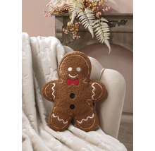 Prydnadskudde i form av en pepparkaksgubbe i teddy-plysch med vita broderier och röd fluga i en fåtölj.