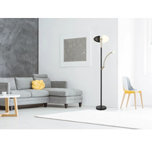 Modern golvlampa med justerbar läsarm i ett ljust vardagsrum med grå hörnsoffa och vit matta.
