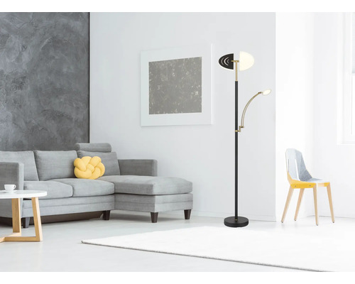 Modern golvlampa med justerbar läsarm i ett ljust vardagsrum med grå hörnsoffa och vit matta.