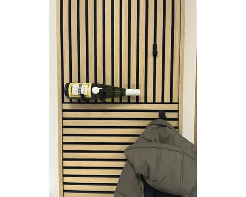 Väggpanel av trälister med integrerad vinflaskhållare och klädkrok.