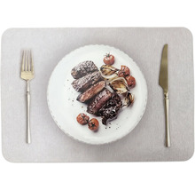 Grillade köttskivor med rostad lök och tomater på en tallrik med gaffel och kniv.
