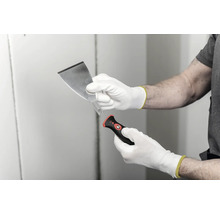Spackel med utbytbart blad och ergonomiskt handtag, hållen med arbetshandskar.