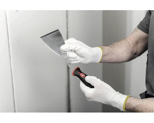 Spackel med utbytbart blad och ergonomiskt handtag, hållen med arbetshandskar.