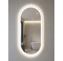 Oval badrumsspegel med LED-belysning runt om, som speglar ett modernt ljust badrum med fristående badkar.