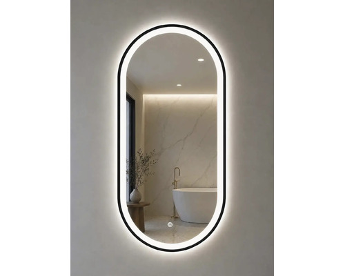 Oval LED-badrumsspegel med svart ram och beröringssensor. Speglingen visar ett ljust, modernt badrum med fristående badkar.