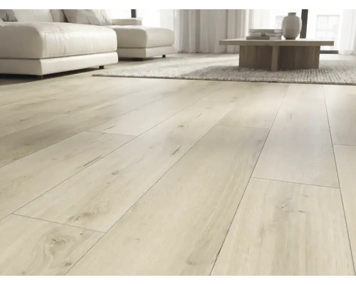 Ljust laminatgolv i eklook lagt som plankgolv i ett modernt, ljust vardagsrum med vit soffa.