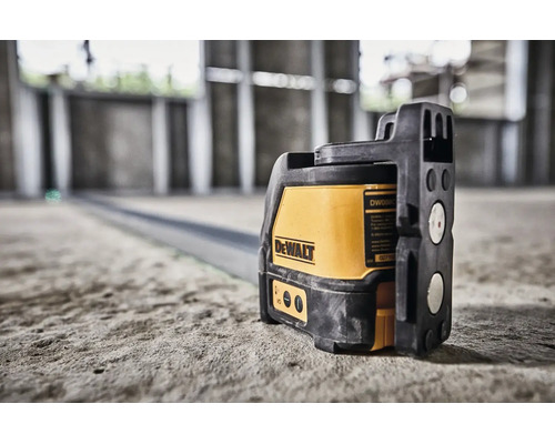 DeWalt korslaser på ett betonggolv i en byggnad under uppförande för exakt inriktning.