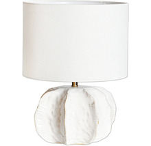Bordslampa med cylindrisk textilskärm och strukturerad keramisk fot i organisk form.