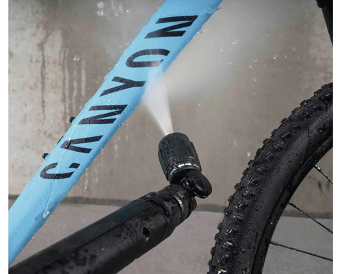 Cykelrengöring med ett högtrycksmunstycke som sprutar vatten på cykelramen