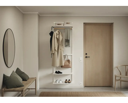 Modern klädhängare med hyllsystem i metall i en ljus hall med trädörr och väggspegel.