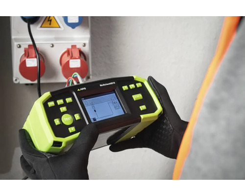 En hantverkare testar ett vägguttag med en KPS Multicheck 6010 testare.