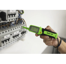En hand använder en digital spänningsprovare av märket KPS på en undercentral med automatsäkringar för elektrisk mätning.