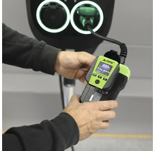 Laddstationstestare KPS FASTCHECK 3010 med digital display för kontroll av laddstolpar för elbilar hållen i en hand.