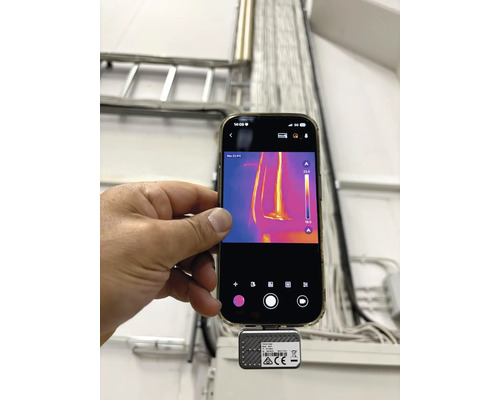 Smarttelefon med ansluten värmekamera för mätning av kablar i en kabelränna.