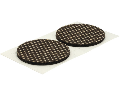 Två runda möbelglidare av filt med nabbar på ett bärepapper
