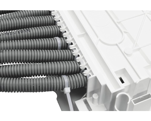 Installation av grå elektriska ledningar på en vit installationsbox med buntband