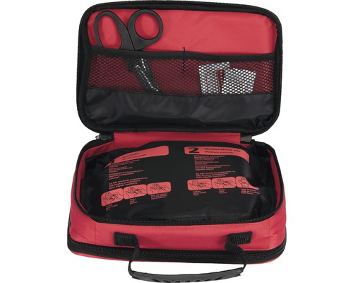 Öppen första hjälpen-väska med sax och förbandsmaterial