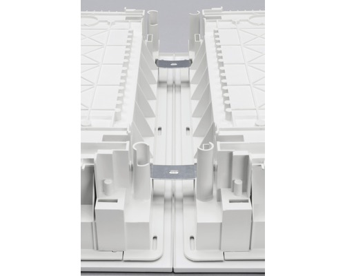 Detaljvy av anslutningselementen i ett vitt underkonstruktionssystem för trädgårdsplattor.