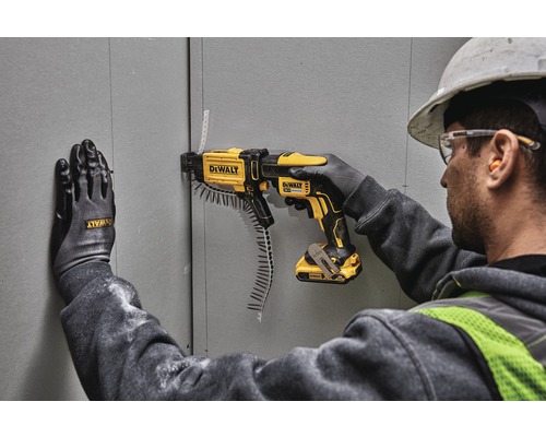 Hantverkare fäster gipsskivor med en DeWalt skruvdragare med magasin