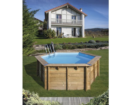 Åttakantig träpool med stege i trädgården framför ett hus.