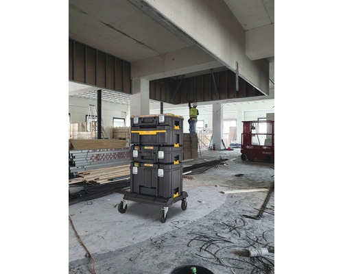 Svart verktygslådetorn på rullbräda i ljus byggarbetsplatsmiljö