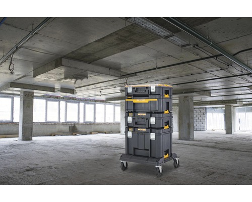 Staplingsbara verktygslådor på rullbräda i oinredd byggnad