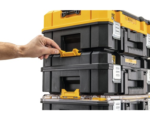 Staplade DeWalt verktygslådor med person som manövrerar det gula spännet