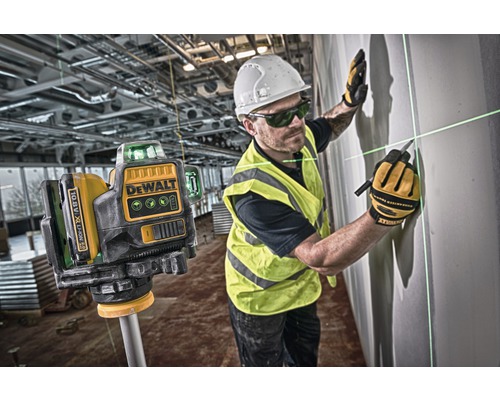 DeWalt linjelaser i bruk med byggnadsarbetare och laserstrålar på en vägg