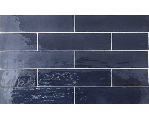 Blå glänsande rektangulära plattor är placerade på en vägg.