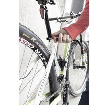 Närbild av en cykel vars sadelstolpe justeras med ett verktyg.