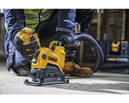 DeWalt spårfräs med en arbetare som använder den och ett dammsugarfäste.