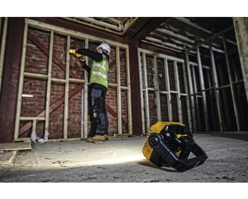 Byggarbetsplats med en arbetare som arbetar med en batteridriven lampa