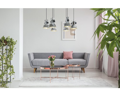 Vardagsrum med grå soffa, soffbord, hänglampor och krukväxter