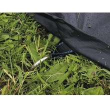 Detaljvy av en tältlina med tältpinne på gräs
