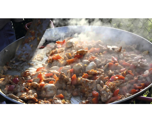 Stor panna med kött och grönsaker tillagas utomhus
