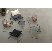 Grupp av svarta metallstolar med kuddar och ett litet bord