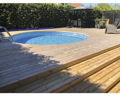 Rund pool med trädäck och trappor i trädgården