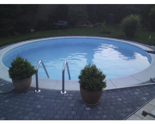 Rund pool med stege i trädgården