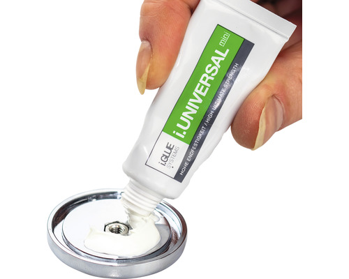 En hand håller en tub i.GLUE SYSTEMS i.UNIVERSAL Mini-lim och applicerar den på en metallskiva.
