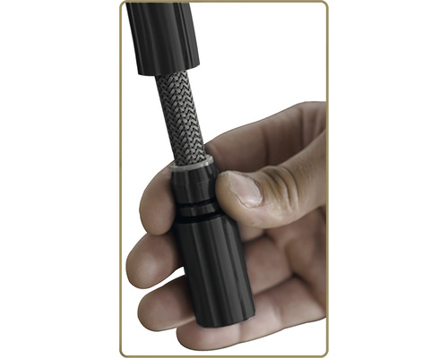 En hand håller en tändstiftskontakt.