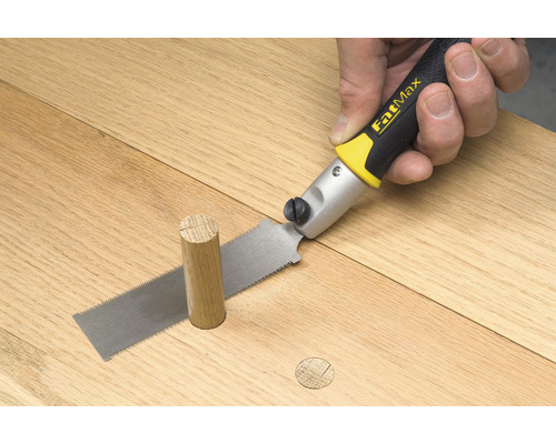 En handsåg skär en träplugg i jämnhöjd med en träyta.