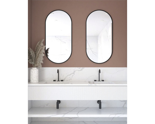 Badrum med dubbla handfat, två ovala speglar och dekorativ vas