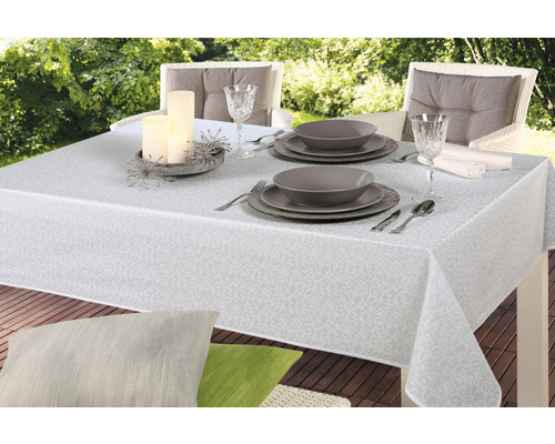 Dukat bord utomhus med duk, tallrikar, glas och ljus