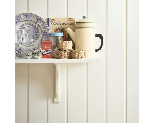 Dekorativa köksredskap på en vit hylla mot en vit vägg