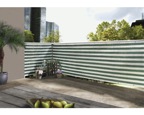 Scen av en balkong med insynsskydd, dekorerad med blommor och en palm i kruka