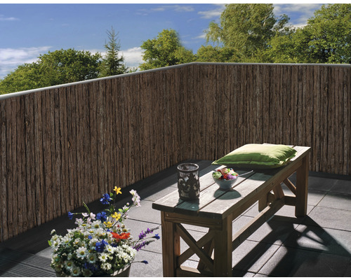 Insynsskyddsmatta i trä på en balkong med en bänk och en växt